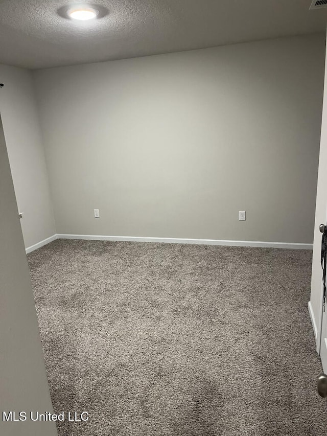 carpeted empty room with a textured ceiling