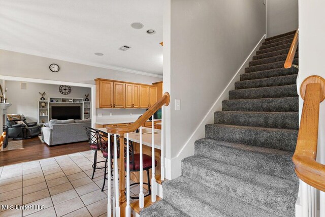 stairway featuring crown molding and hardwood / wood-style floors