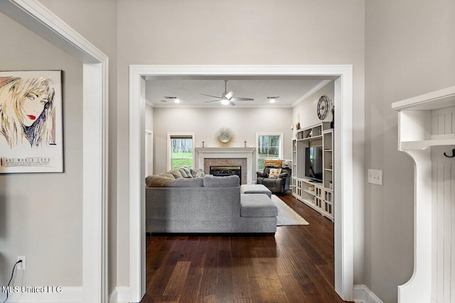 living room with dark wood-type flooring, ceiling fan, and ornamental molding