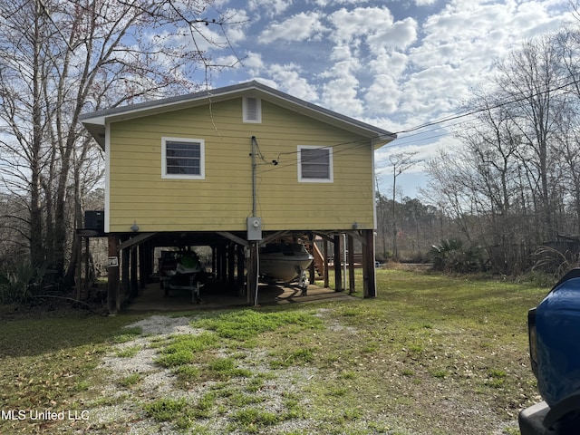 back of house with a yard and a carport