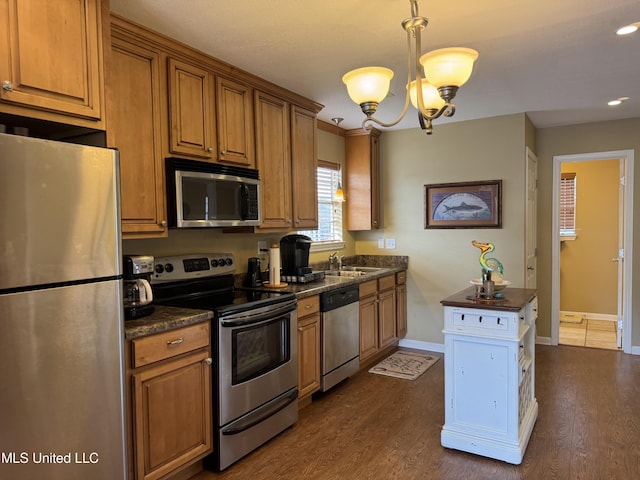 kitchen featuring sink, dark wood-type flooring, an inviting chandelier, hanging light fixtures, and stainless steel appliances