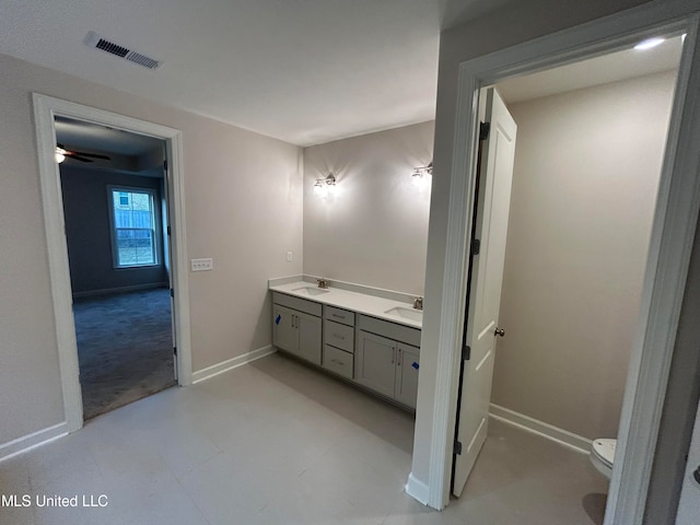 bathroom with toilet, vanity, and ceiling fan