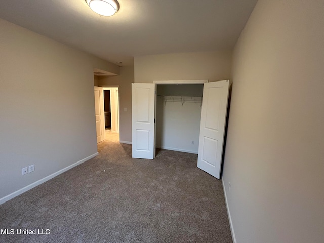 unfurnished bedroom featuring dark carpet and a closet