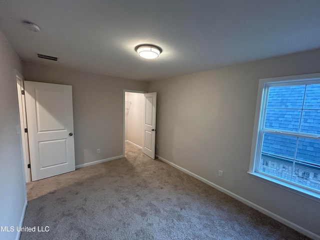 unfurnished bedroom with multiple windows and light colored carpet