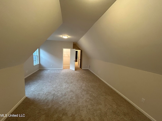 additional living space featuring lofted ceiling and carpet