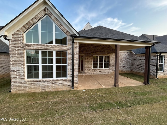 back of property featuring a yard and a patio