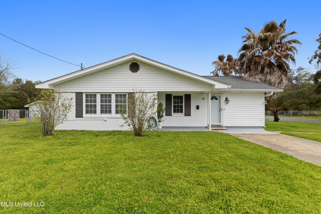 ranch-style home with roof with shingles, covered porch, a front lawn, and fence