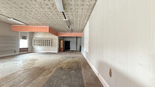 unfurnished living room with concrete floors and rail lighting