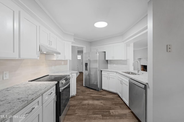 kitchen with appliances with stainless steel finishes, backsplash, sink, white cabinets, and dark hardwood / wood-style floors