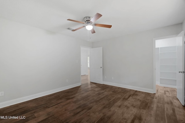 unfurnished room with ceiling fan and dark hardwood / wood-style flooring