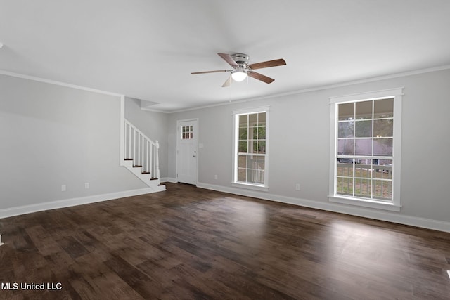 spare room featuring dark wood-type flooring, crown molding, ceiling fan, and a healthy amount of sunlight