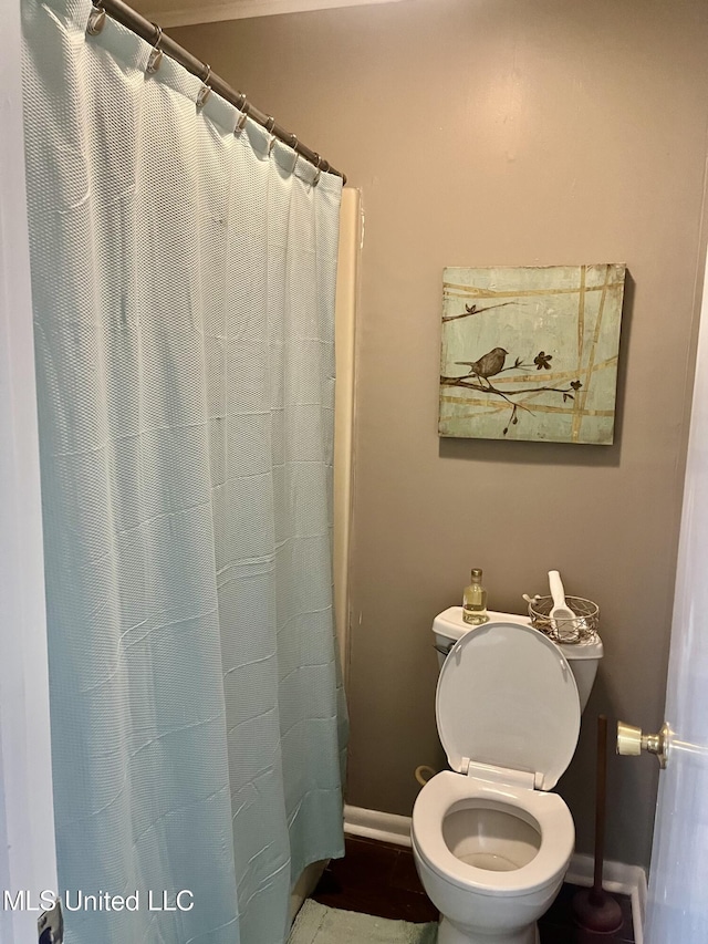 506 Holmes St, Belzoni, MS 39038 - full bathroom featuring baseboards and curtained shower