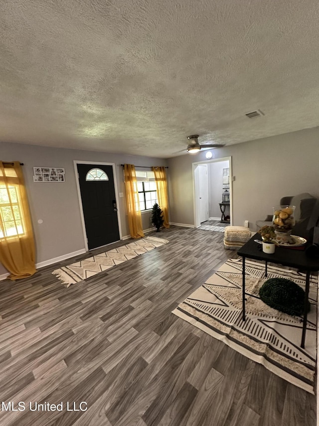 living room featuring ceiling fan, wood-type flooring, and a textured ceiling