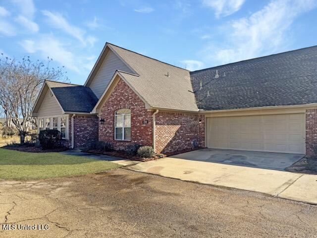 front facade featuring a garage and a front lawn