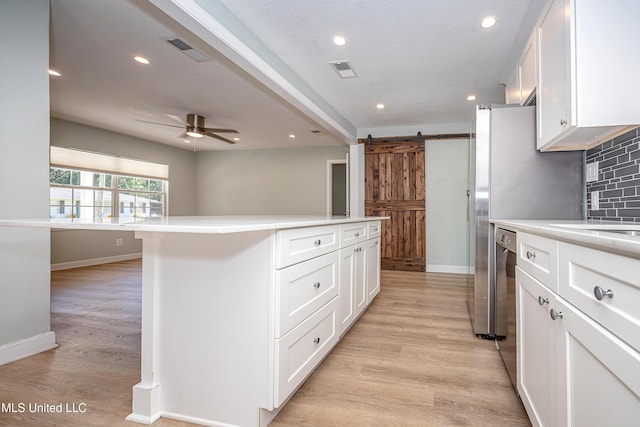 209 Audrey Cir, Ocean Springs, MS 39564 - kitchen with baseboards, a barn door, decorative backsplash, white cabinets, and recessed lighting