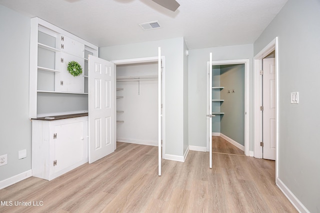 209 Audrey Cir, Ocean Springs, MS 39564 - unfurnished bedroom featuring light wood-style floors, baseboards, a ceiling fan, and a closet