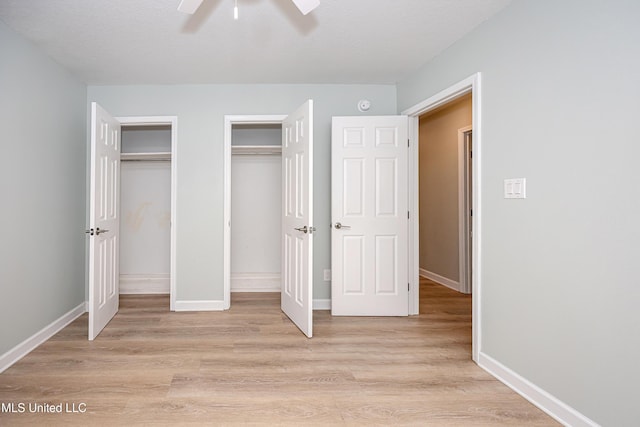 209 Audrey Cir, Ocean Springs, MS 39564 - unfurnished bedroom with multiple closets, light wood finished floors, baseboards, and a ceiling fan