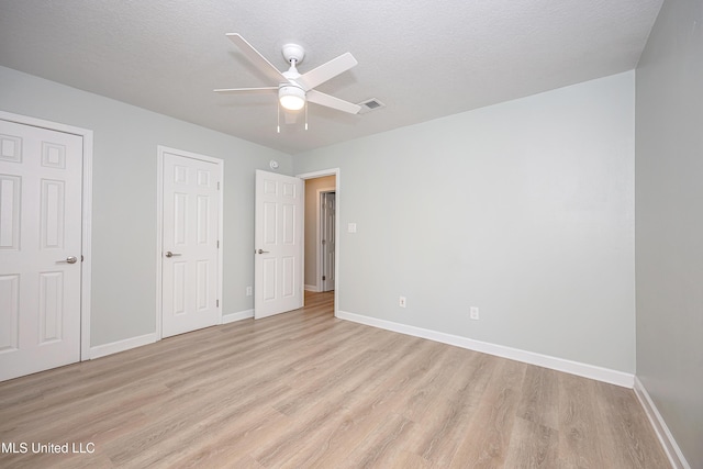 209 Audrey Cir, Ocean Springs, MS 39564 - unfurnished bedroom with light wood-style floors, baseboards, a ceiling fan, and a textured ceiling