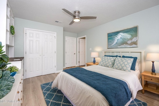 209 Audrey Cir, Ocean Springs, MS 39564 - bedroom featuring light wood finished floors, a textured ceiling, a ceiling fan, and a closet