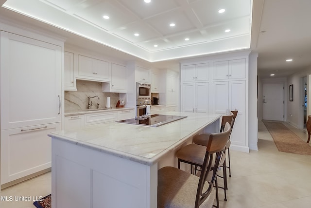 2668 Beach Blvd Unit 1704, Biloxi, MS 39531 - kitchen featuring coffered ceiling, black electric stovetop, recessed lighting, a sink, and a kitchen breakfast bar