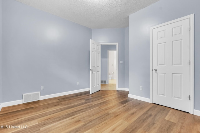 700 Martin Luther King Jr Dr, Holly Springs, MS 38635 - unfurnished bedroom featuring wood finished floors, a textured ceiling, and baseboards