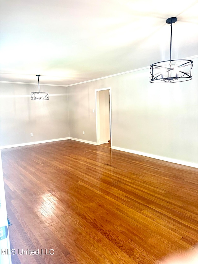 interior space with crown molding, hardwood / wood-style flooring, and an inviting chandelier