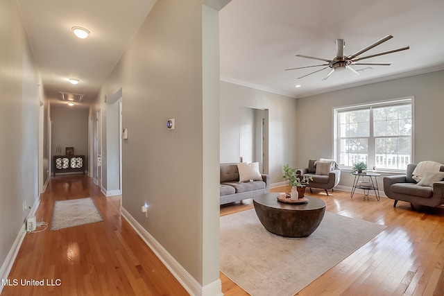 living room featuring ornamental molding, ceiling fan, and light hardwood / wood-style floors