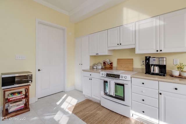 kitchen with white cabinets, ornamental molding, and electric range