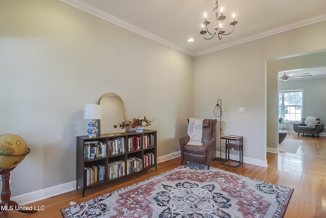 sitting room with wood-type flooring, ceiling fan with notable chandelier, and crown molding