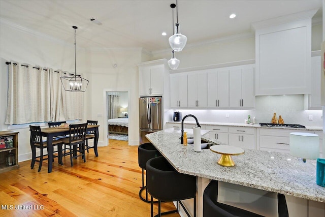 1622 Old Lake Rd, Brandon, MS 39042 - kitchen featuring stainless steel appliances, a sink, ornamental molding, white cabinets, and a chandelier