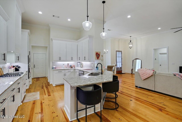 1622 Old Lake Rd, Brandon, MS 39042 - kitchen featuring a sink, crown molding, stainless steel appliances, white cabinetry, and a kitchen breakfast bar