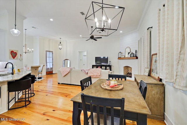 1622 Old Lake Rd, Brandon, MS 39042 - dining room featuring a chandelier, ornamental molding, light wood-style floors, recessed lighting, and a fireplace