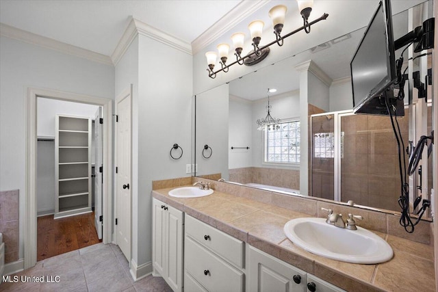 bathroom featuring walk in shower, vanity, a notable chandelier, ornamental molding, and tile patterned flooring