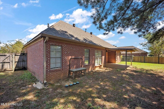 rear view of house featuring a patio area and a yard