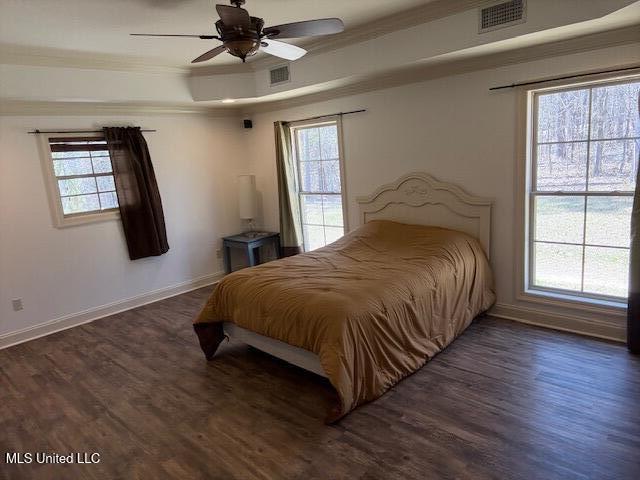 bedroom featuring baseboards, crown molding, visible vents, and dark wood-style flooring