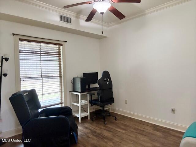 office space with visible vents, crown molding, baseboards, and wood finished floors