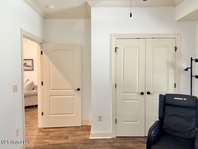 interior space featuring baseboards, wood finished floors, and crown molding