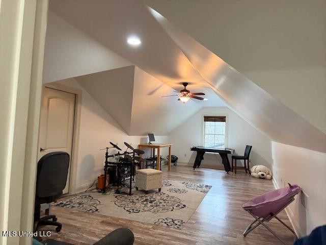 additional living space with a ceiling fan, vaulted ceiling, and wood finished floors