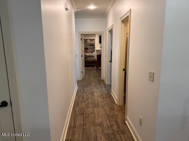 hallway featuring dark wood-style floors, baseboards, and crown molding