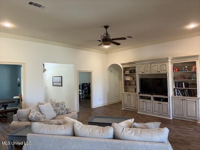 living area featuring dark wood-style floors, visible vents, arched walkways, and ceiling fan