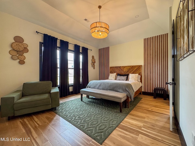 bedroom featuring a chandelier and light wood-type flooring
