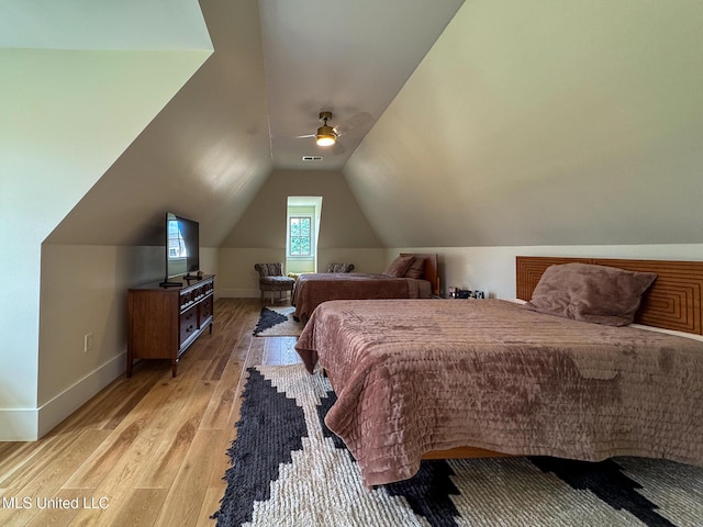 bedroom with light wood-style floors, lofted ceiling, baseboards, and a ceiling fan