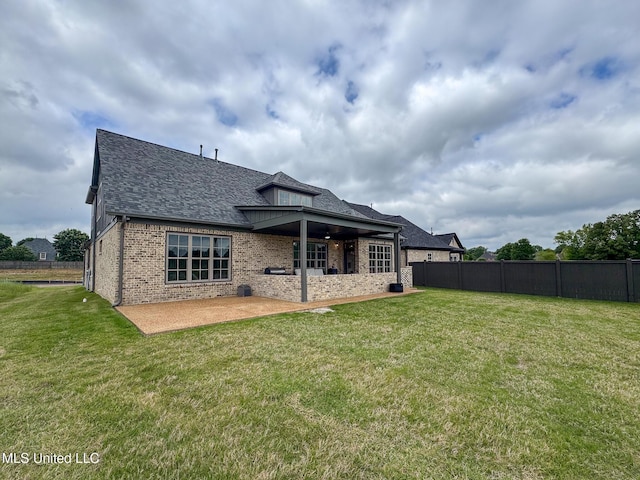back of property with a patio area, roof with shingles, and brick siding
