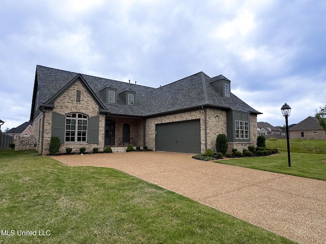 french provincial home with brick siding, a front yard, driveway, roof with shingles, and an attached garage
