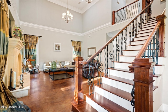 entrance foyer featuring crown molding, a towering ceiling, and an inviting chandelier