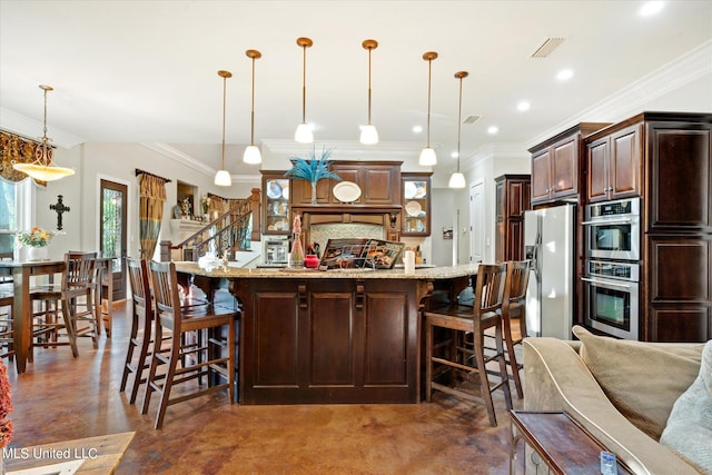 kitchen with a breakfast bar area, ornamental molding, decorative light fixtures, and stainless steel appliances