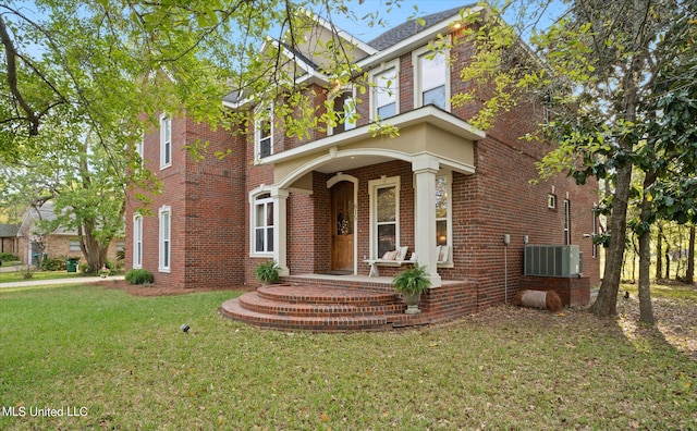 view of front of property featuring a front yard, covered porch, and central AC unit