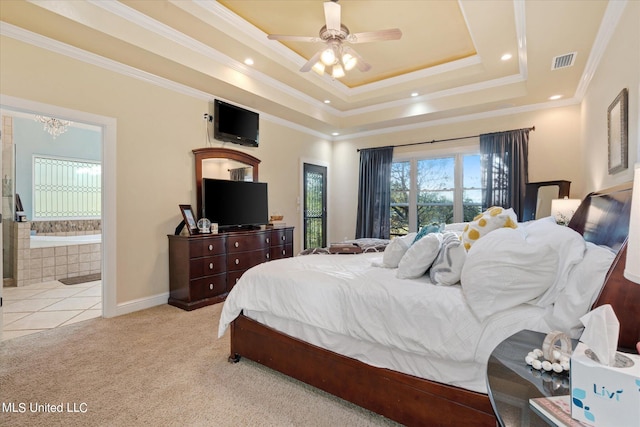 carpeted bedroom featuring ceiling fan, ornamental molding, a tray ceiling, and ensuite bath