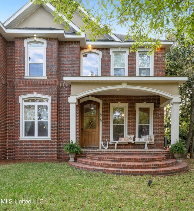 view of front of property with a porch and a front lawn