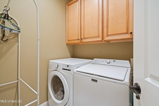 laundry area with washing machine and dryer and cabinets